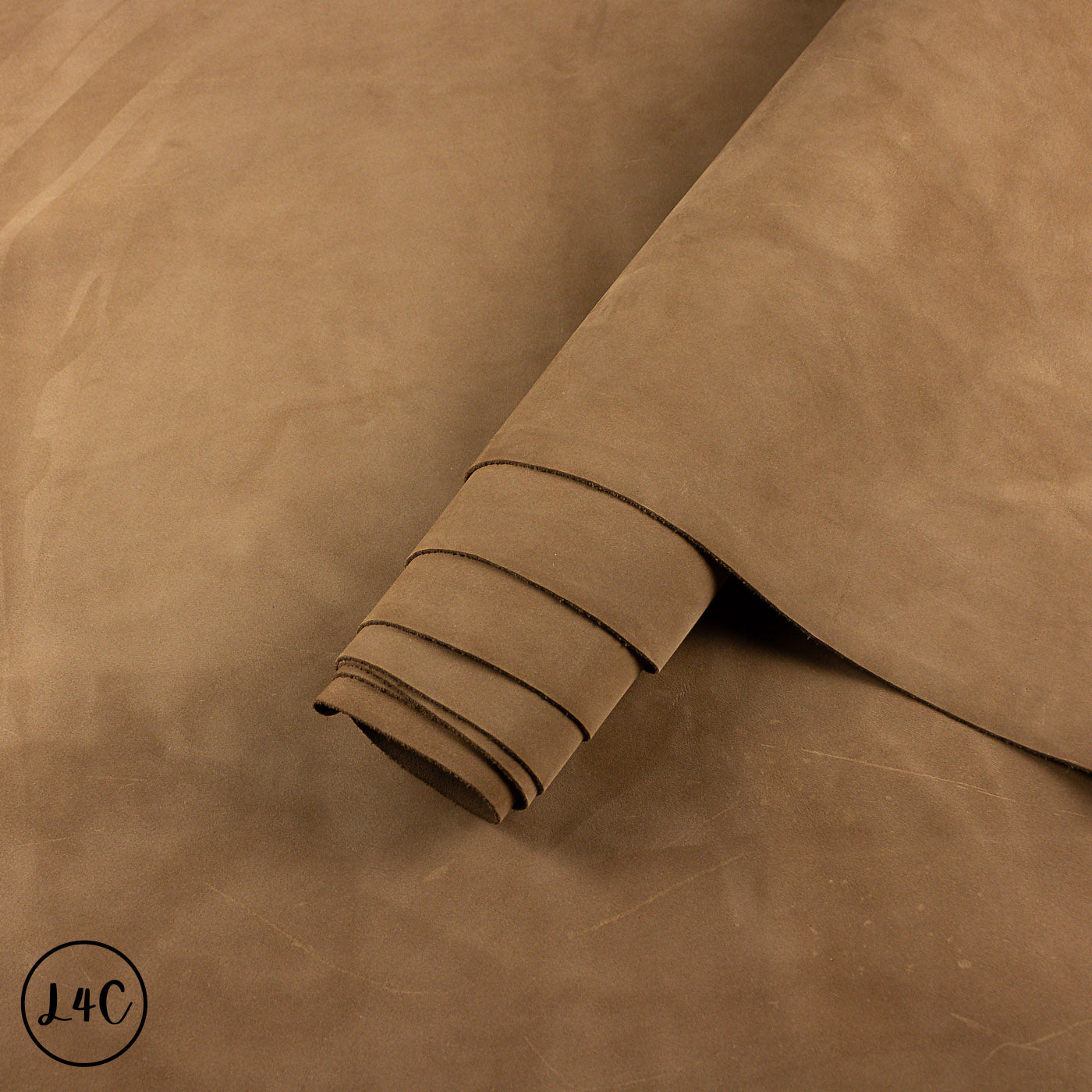 Brown nubuck leather hide rolled up, displaying texture and colour.