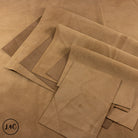 Stack of brown nubuck leather panels on a brown background