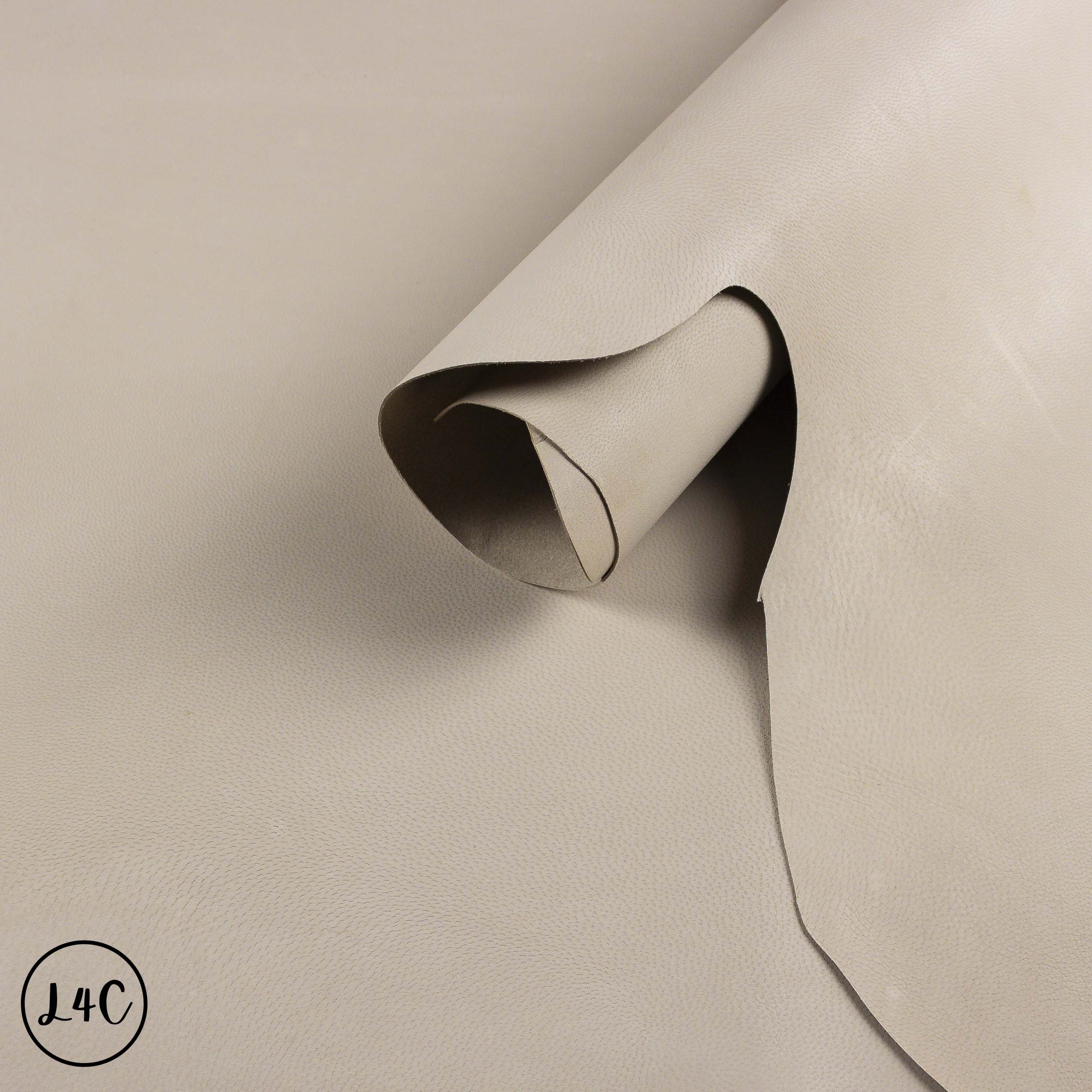 Beige leather sample with a visible crease on a beige background