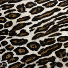 Close-up of leopard print fabric with black and brown spots on a white background.