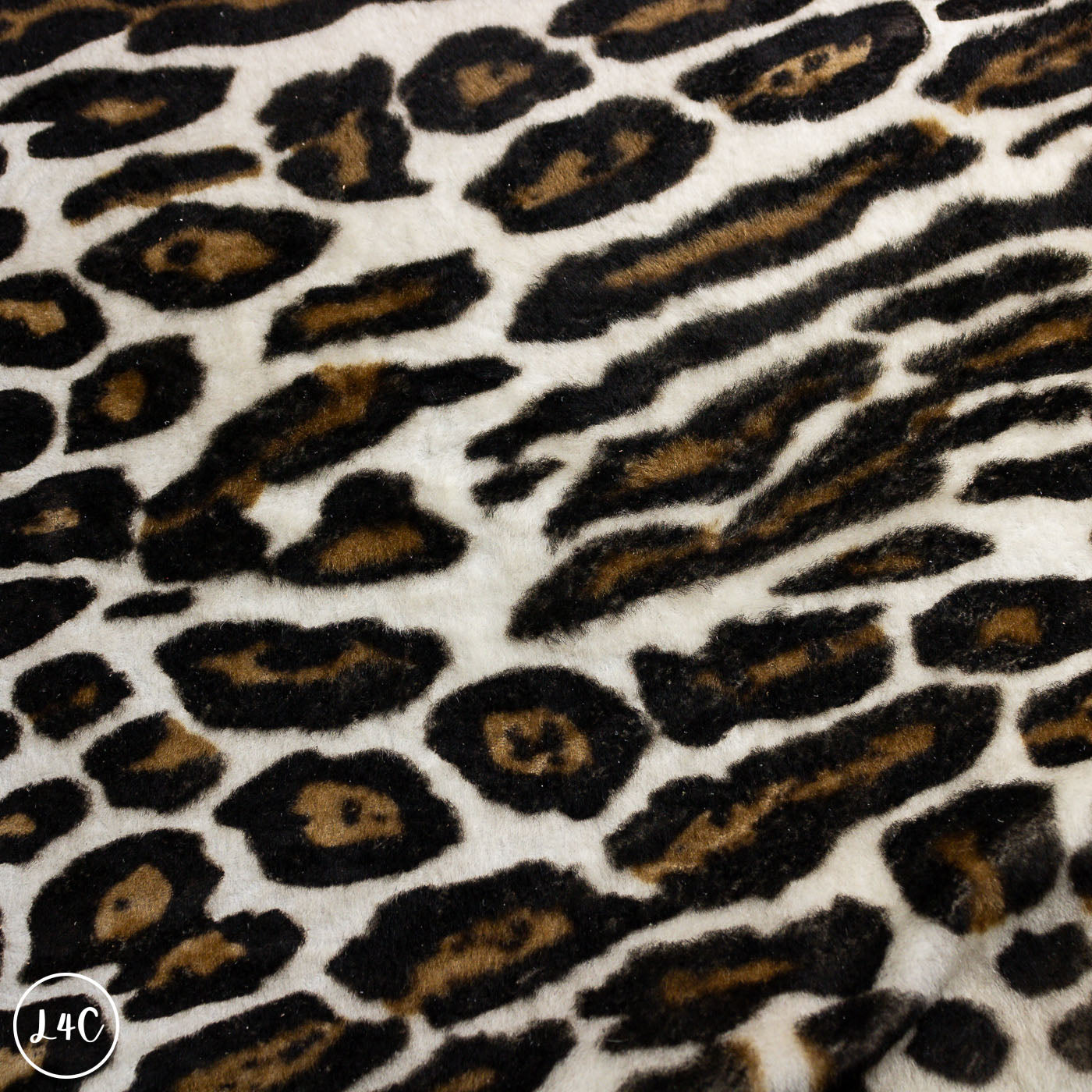 Close-up of leopard print fabric with black and brown spots on a white background.