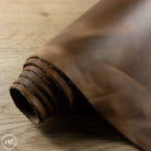Rolled-up brown leather on a wooden surface