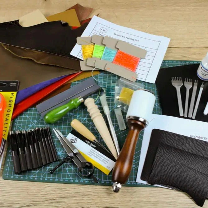 Collection of leatherworking tools and materials on a cutting mat
