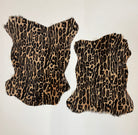Two leopard print fur hides on a white background