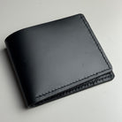 Black leather wallet on a light gray background
