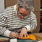 Person cutting leather with scissors on a table