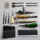 Collection of leatherworking tools on a gray background