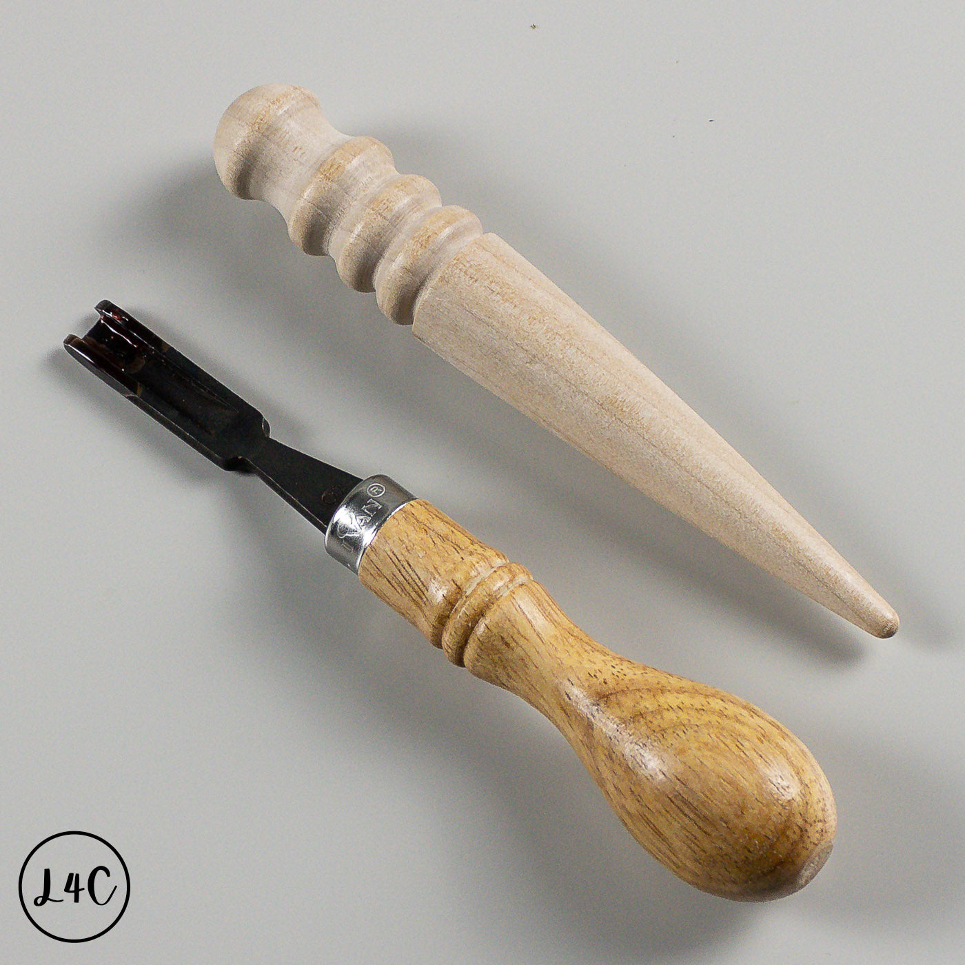Two wooden tools with metal blades on a gray background