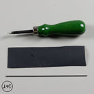 Green tool with black leather strip and metal rod on a gray background