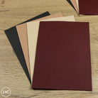 Set of leather panels in various colors on a wooden surface