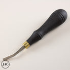 Black leather tool with gold accent on a white background