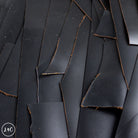 Scattered pieces of black leather on a dark background