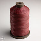 Spool of MeiSi Waxed Linen Thread on a gray background