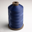 Spool of blue thread on a white background