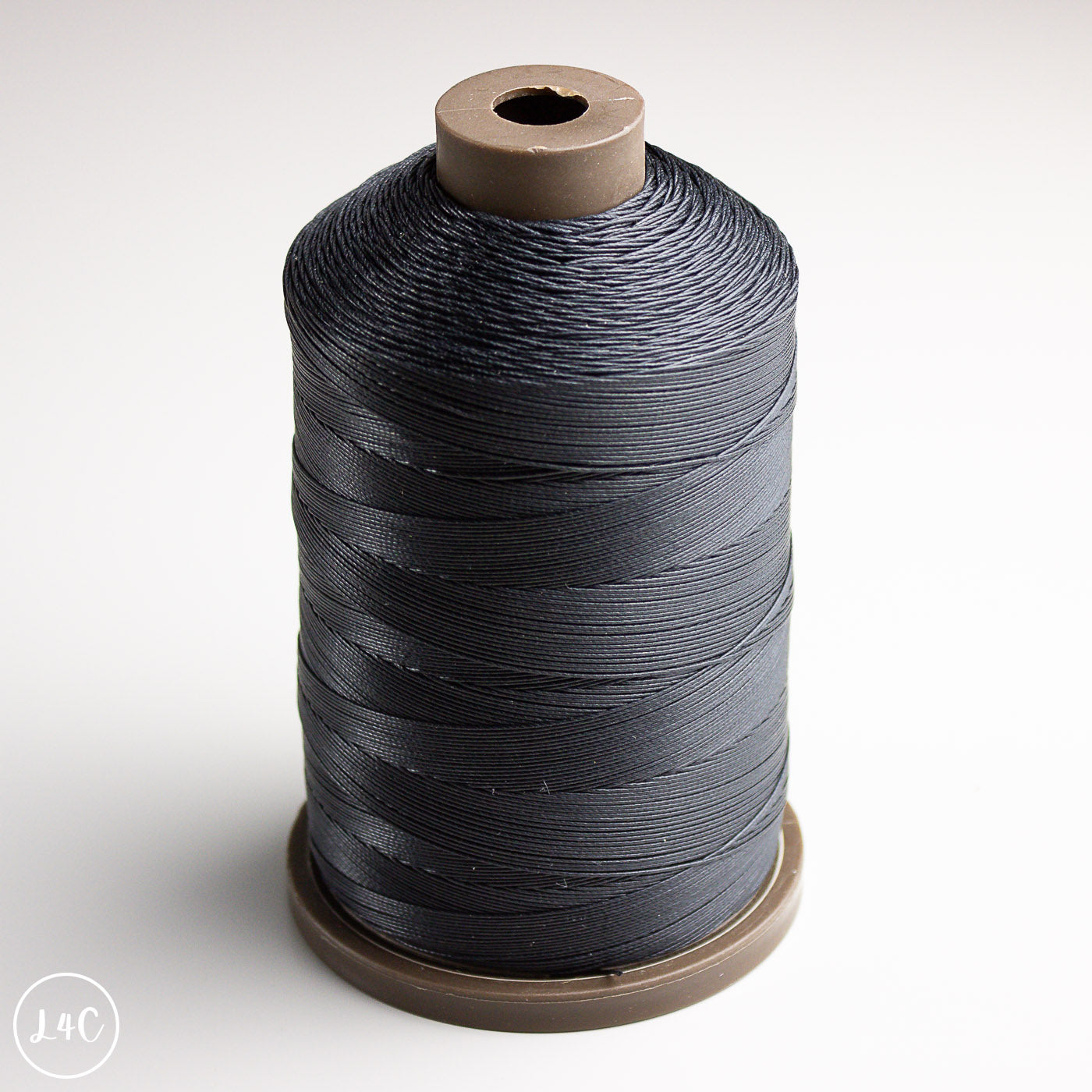 Spool of black thread on a white background