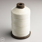 Spool of white thread on a gray background