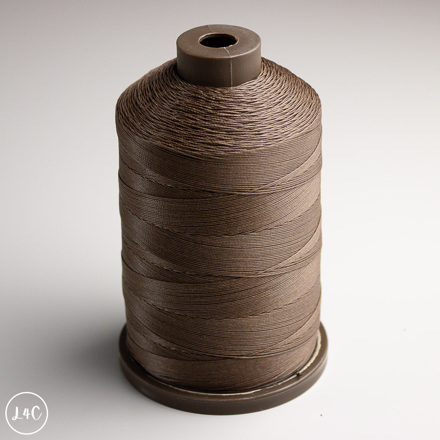 Spool of brown thread on a white background
