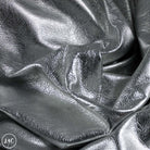 Close-up of silver metallic fabric with a crumpled texture