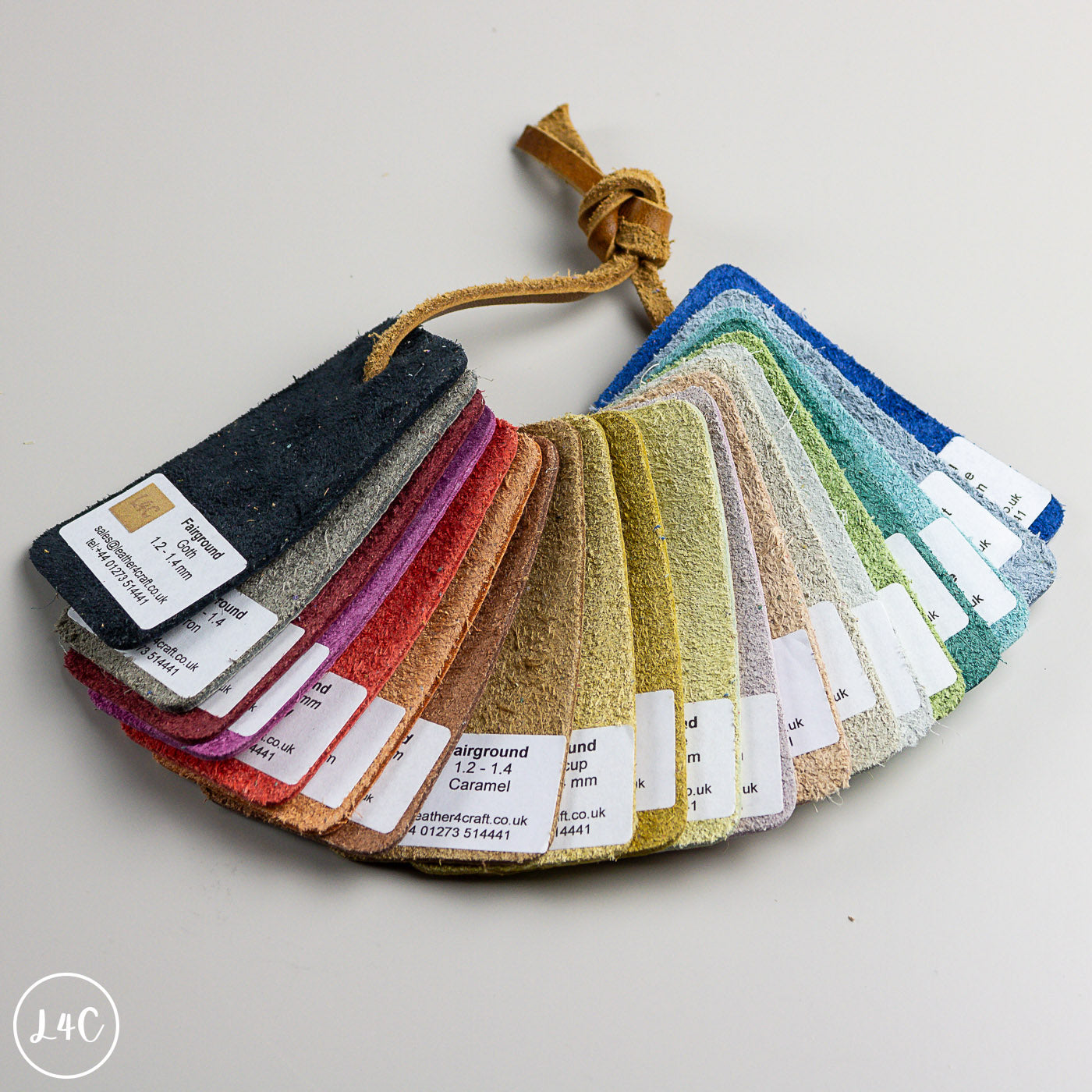 A fabric color swatch fan with multiple textured material samples in different colors, each labeled with a white tag, photographed on a light neutral background.