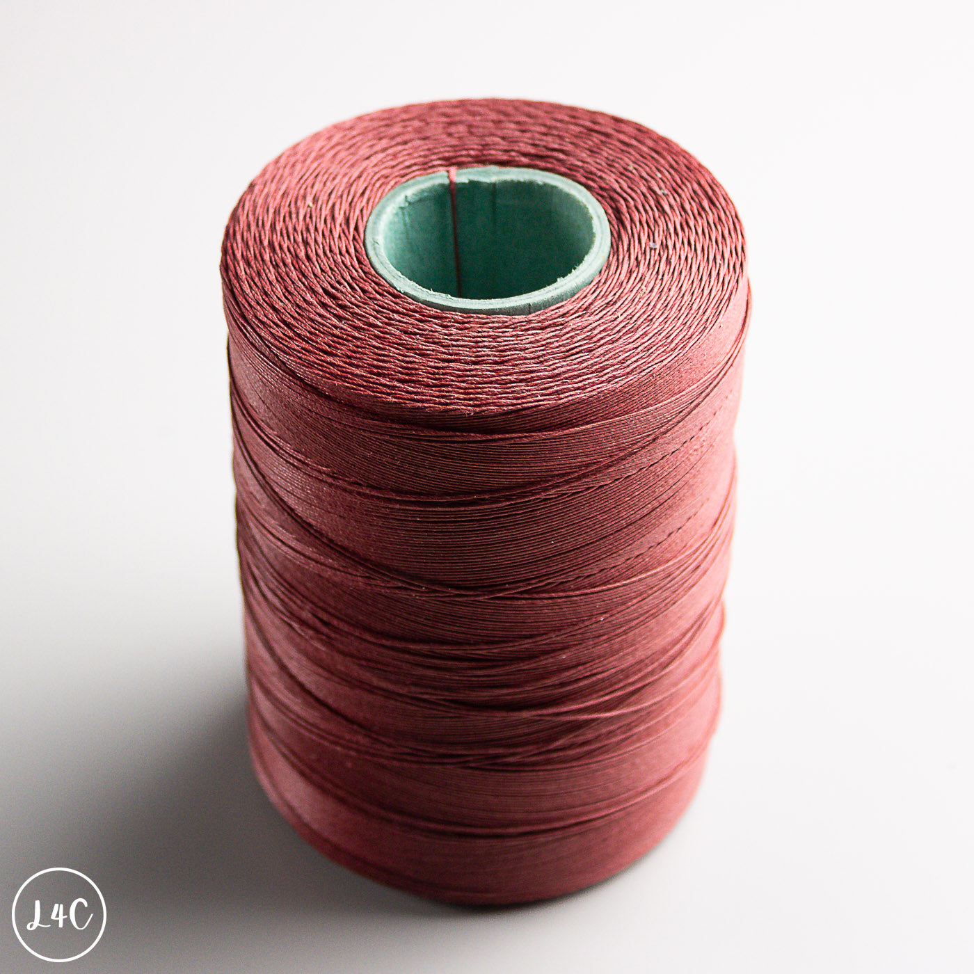 Spool of red thread on a white background