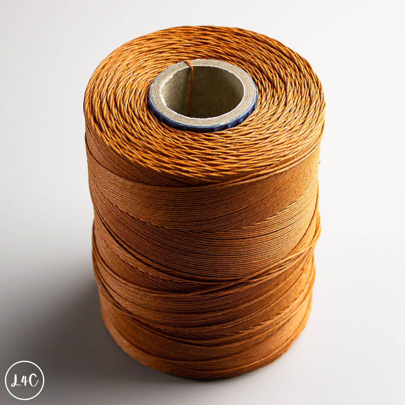 Spool of brown thread on a white background
