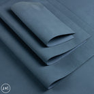A folded piece of dark slate blue nubuck leather, showing its matte texture and soft drape.