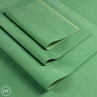 A close-up of folded green leather panels. 