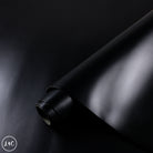 Roll of black leather on a dark background