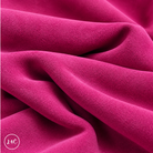 A close-up of draped dark pink suede leather with a soft, plush texture, showing deep folds and shadows. 