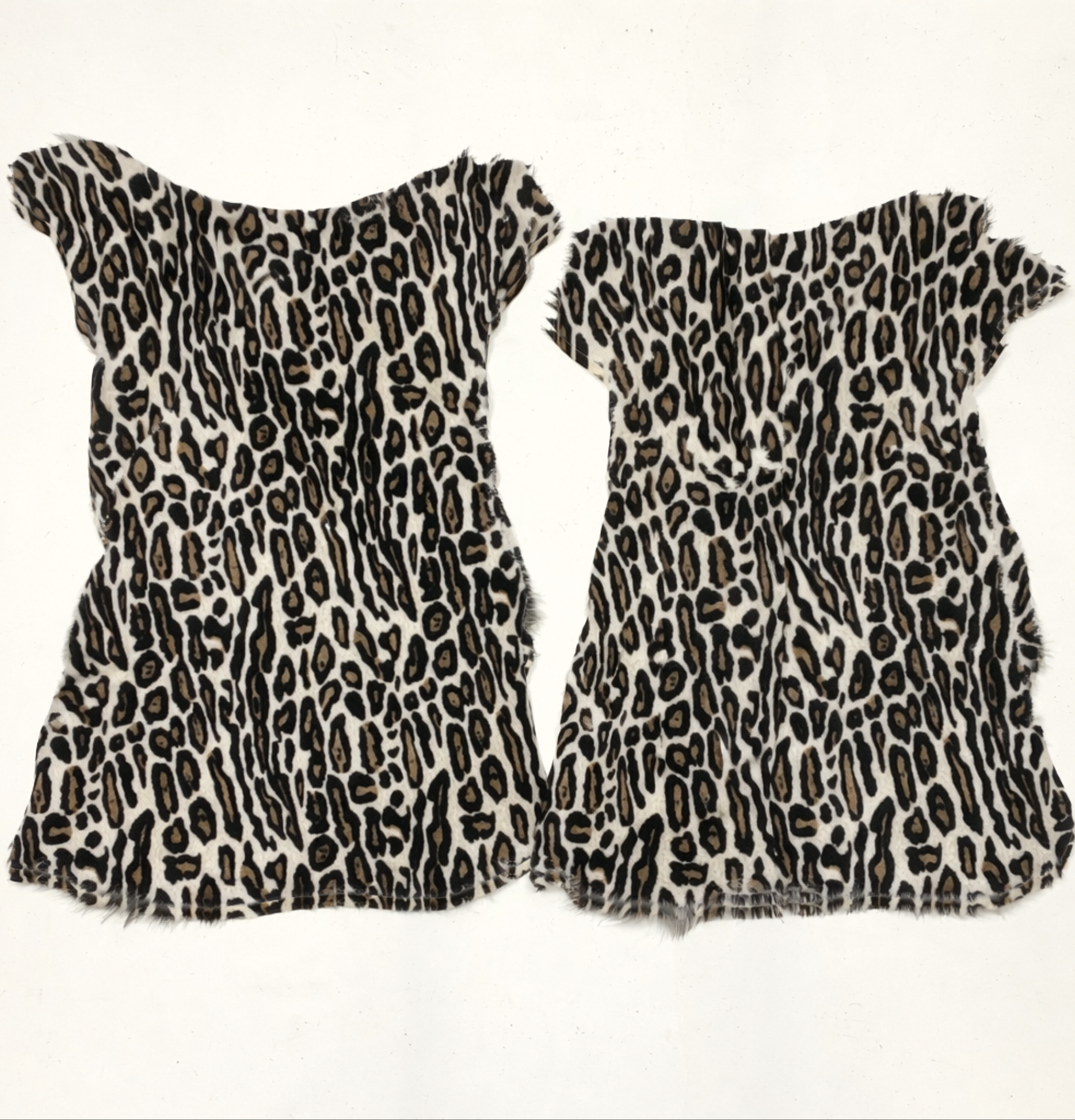 Two snow leopard print hides on a white background