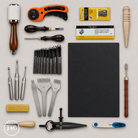 Collection of leatherworking tools and supplies on a light gray background