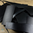 Black leather off cuts on a wooden surface with 'conceria WALPIER' branding.