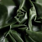Dark olive green leather draped in soft folds, showing a smooth texture and glossy sheen.