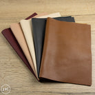 Collection of pebbled leather sheets in various colors on a wooden surface