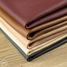Stack of leathers in various colors on a wooden surface