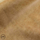 A close-up of textured tan leather with a pebbled grain surface.