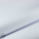 A close-up of a light gray pebbled faux leather or vinyl material, folded diagonally to show its texture and sheen.