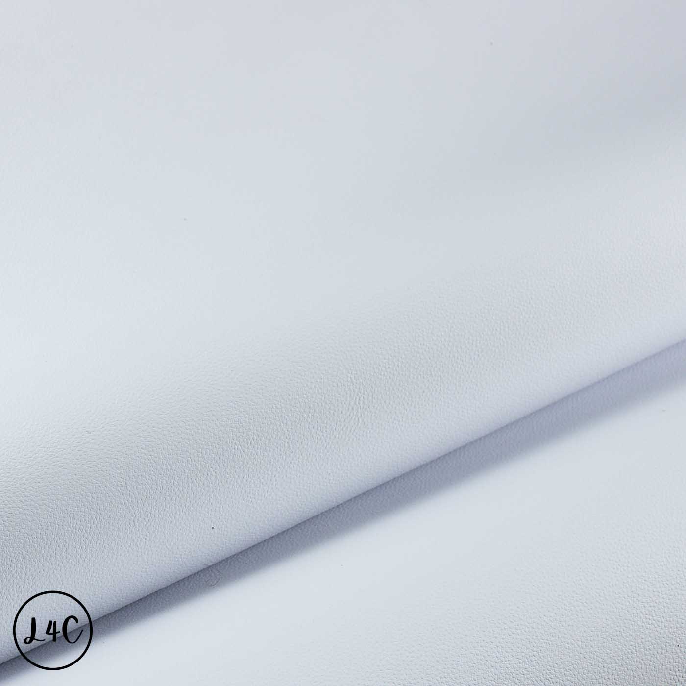 A close-up of a light gray pebbled faux leather or vinyl material, folded diagonally to show its texture and sheen.