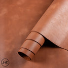 Close-up of brown leather with a rolled edge on a matching brown background.