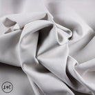 Close-up of gray fabric with folds on a light gray background