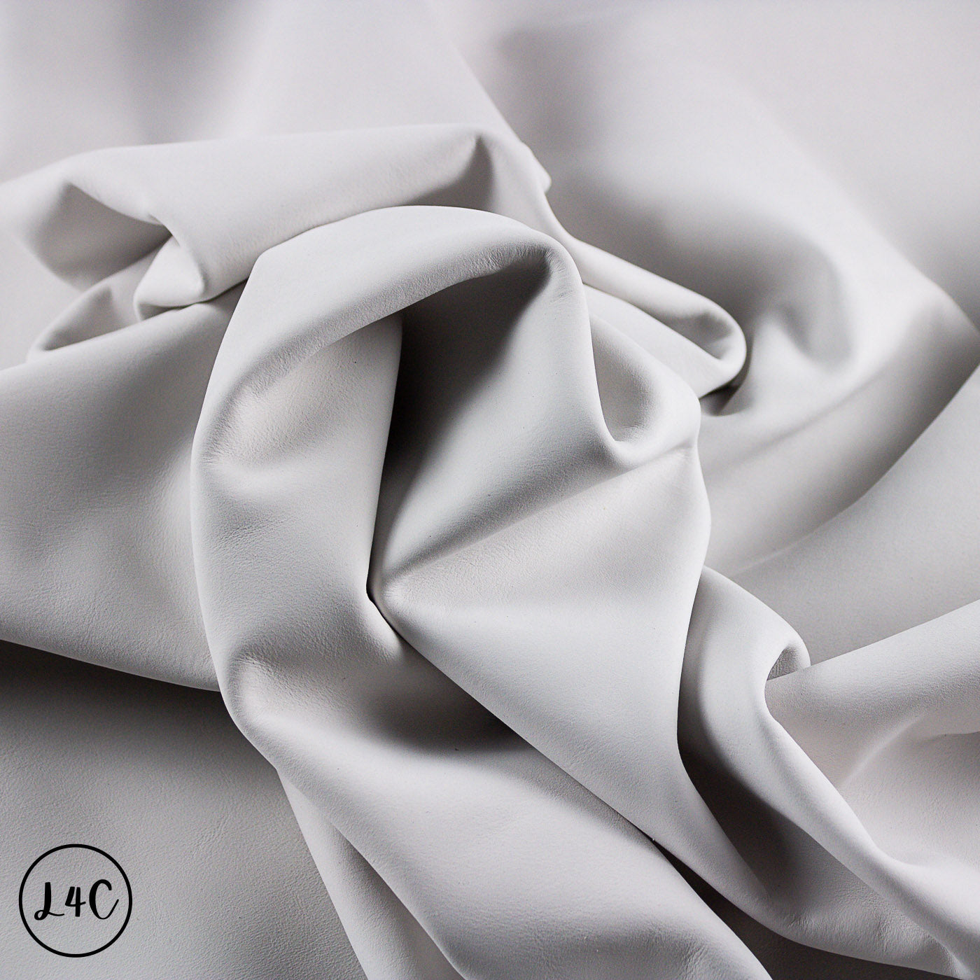 Close-up of gray fabric with folds on a light gray background